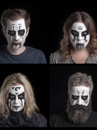 Fyra vuxna, två män och två kvinnor, 30–50 år, med svartvit ansiktsmålning i mörka tröjor/blus; en med långt skägg, mot svart bakgrund.