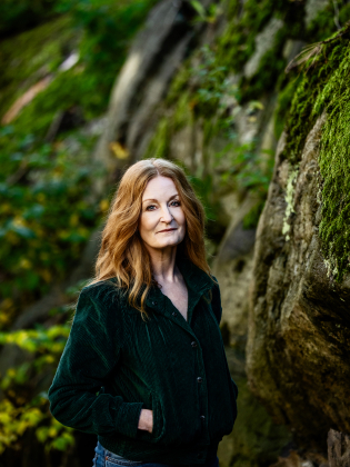 En kvinna fotad framför en bergvägg