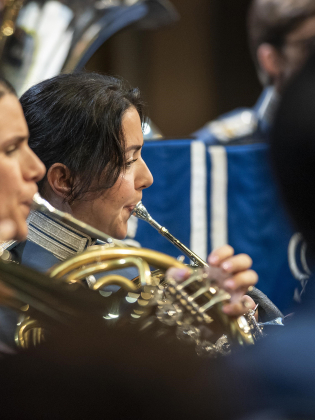 Personer i militära uniformer spelar olika instrument.