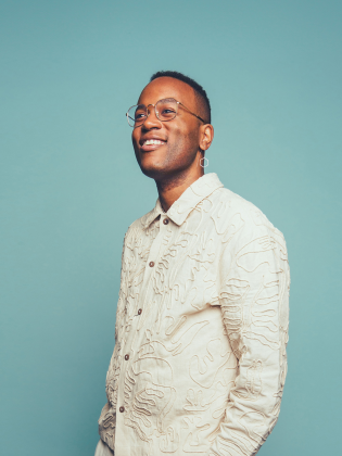 En man i vitt framför turkos bakgrund