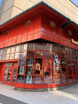 Exteriör av en röd byggnad med stora glasfönster vid Kulturhuset Stadsteatern.