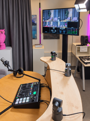 Översikt av Lava Studio med poddbord, mikrofoner, kameror och arbetsstation för musikproduktion. 
