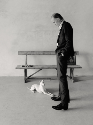 Svartvit bild på man som står och tittar på en hund