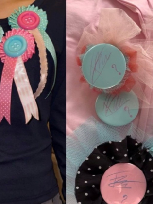Närbild på handgjorda rosetter och pins i rosa, turkost och grönt med knappar, band och tyll. En person bär flera rosetter på tröjan.